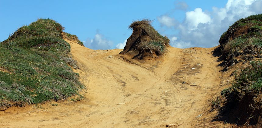 Sand trails converge over a hilltop.