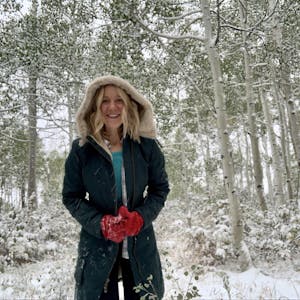 A woman smiles in the snow.