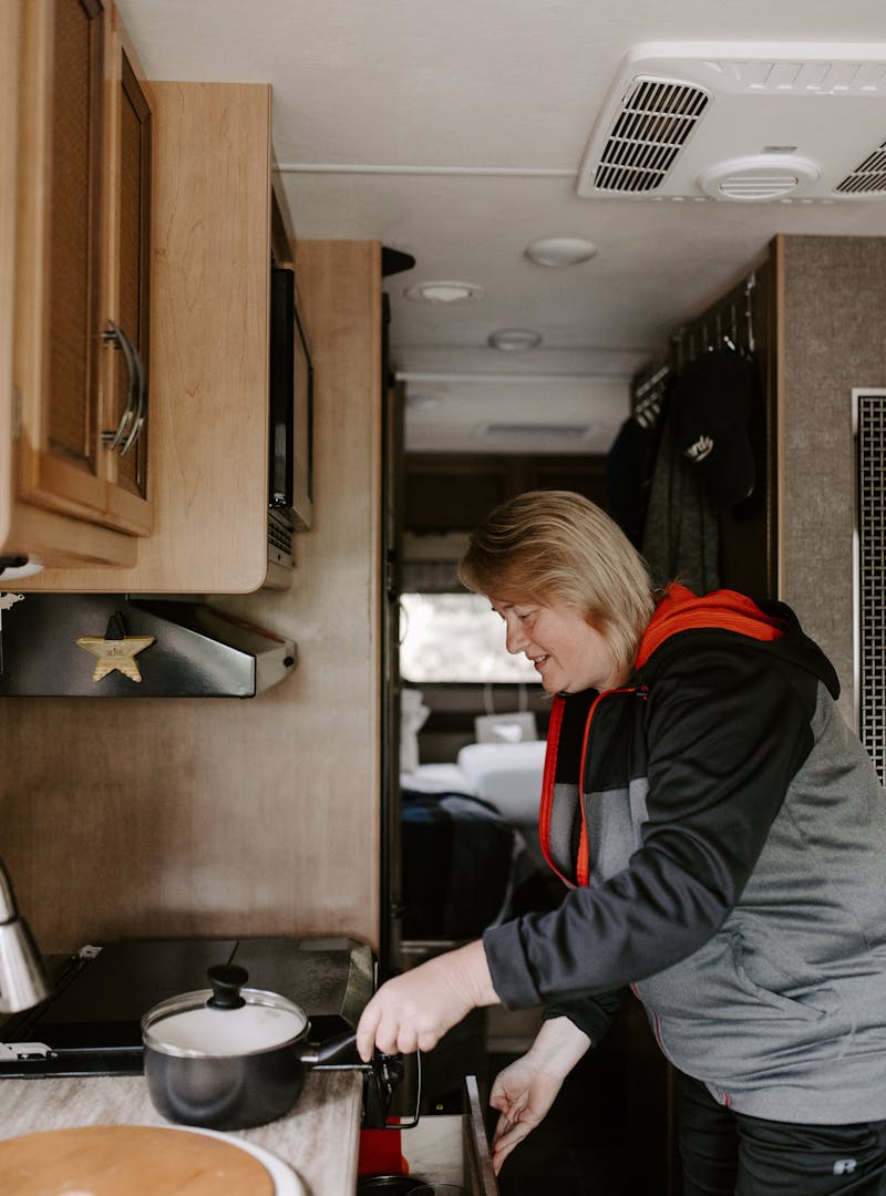Kathy cooking inside her RV kitchen.