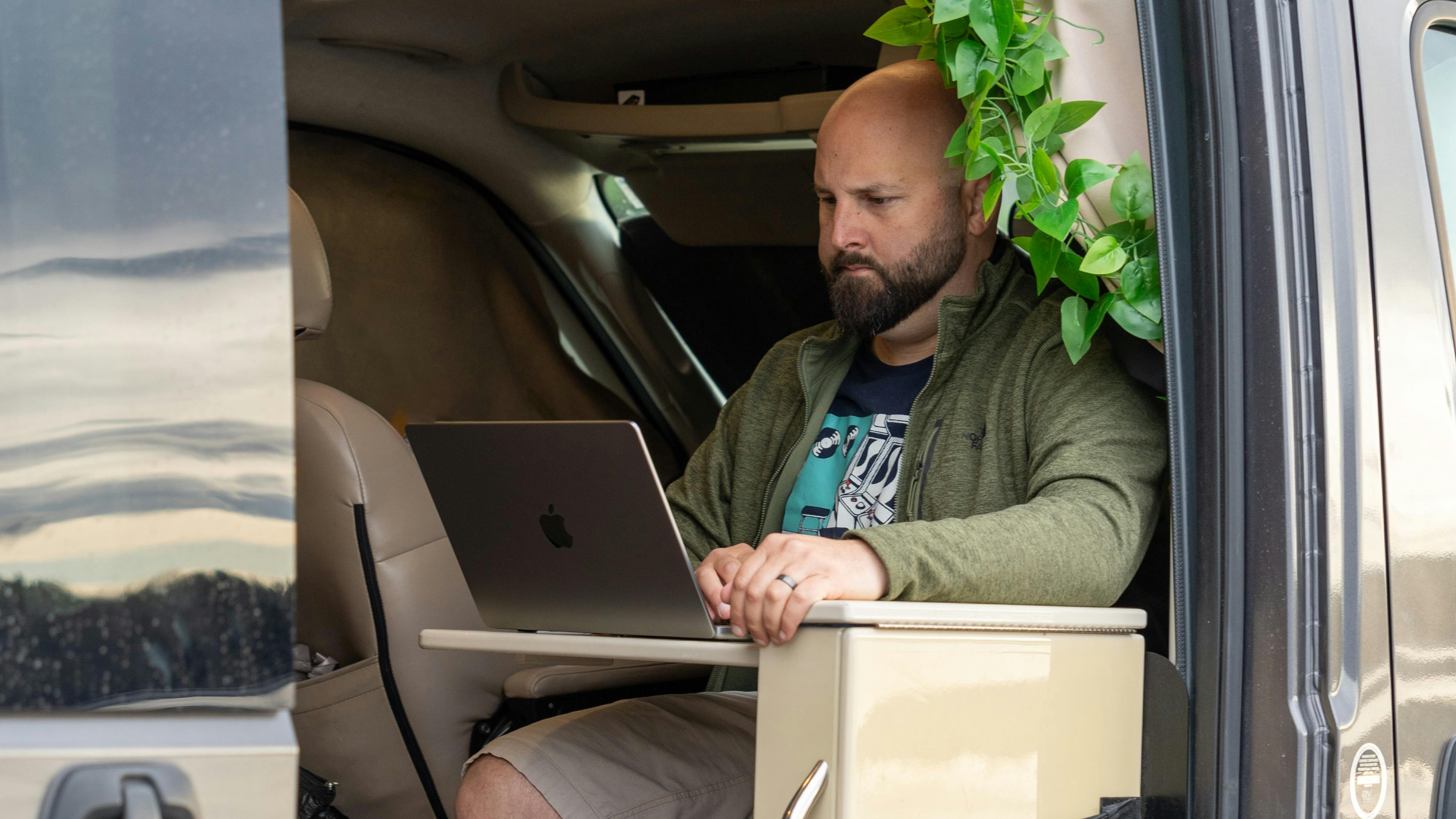 Rocio Rivero working at his laptop inside his camper van