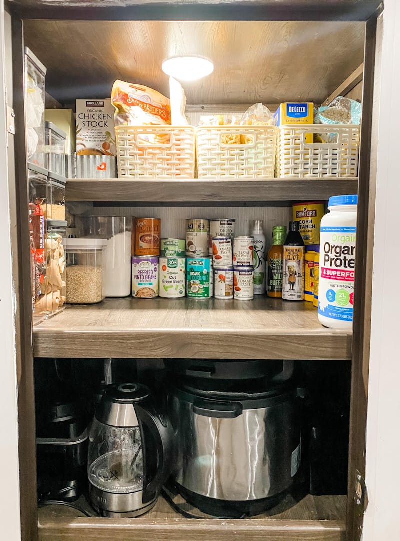 A shot of Brittnee Proha's pantry that is organized using pull out baskets to optimize storage in her Heartland Cyclone.