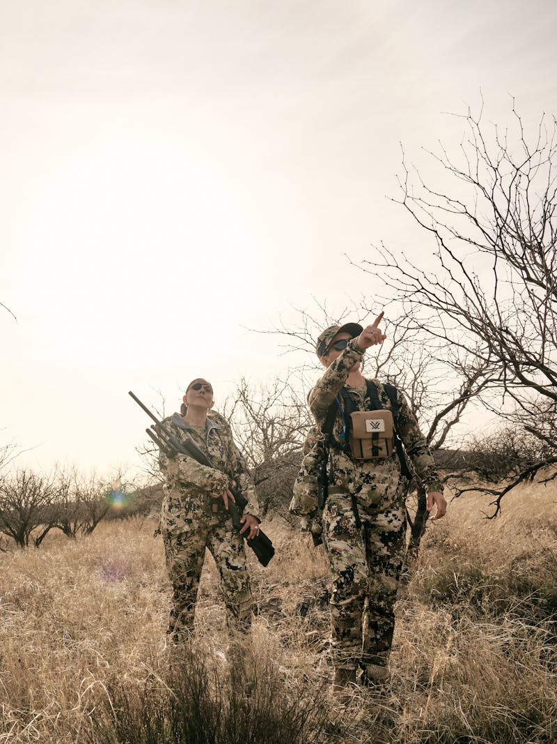 Two veteran women on a hike during a hunt looking for javelina 