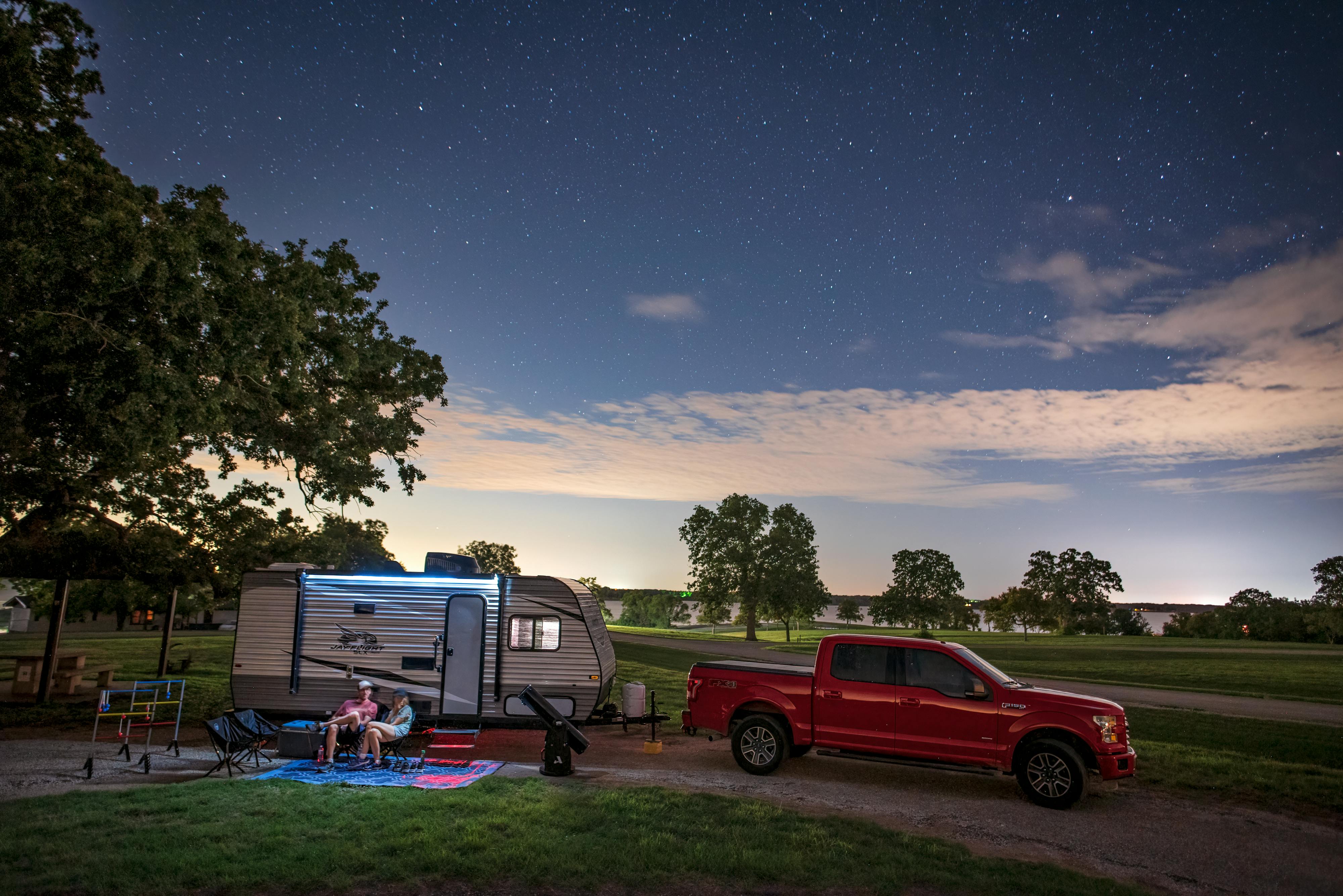 Jason and Alison Takacs at their RV campsite with their truck headlights off