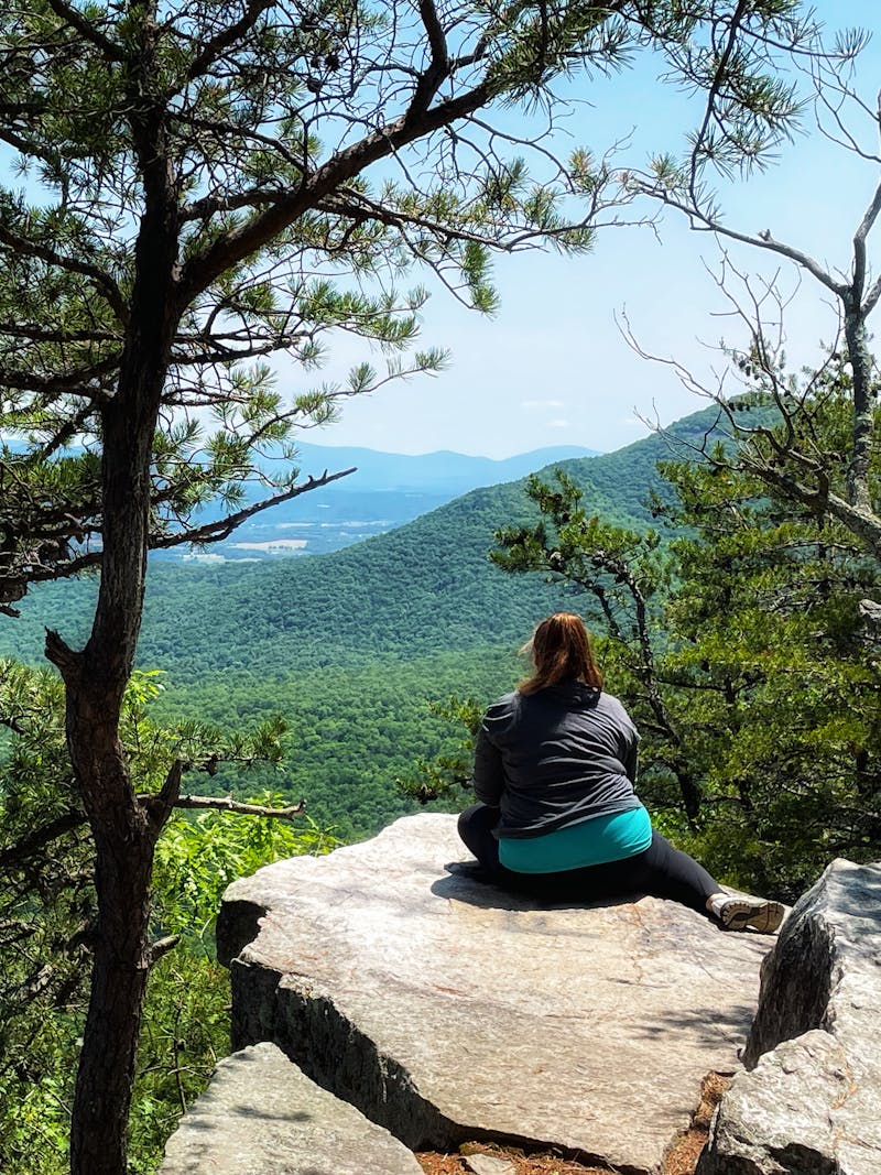 CHRISTINA MCMILLAN sitting on a rock in George Washington and Jefferson National Forest