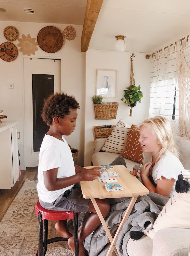 Shannon Carew's children play card games together inside their Highland Ridge RV.