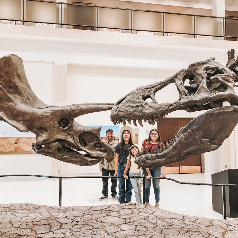 The O'Neill family standing with dinosaur bones at a museum.