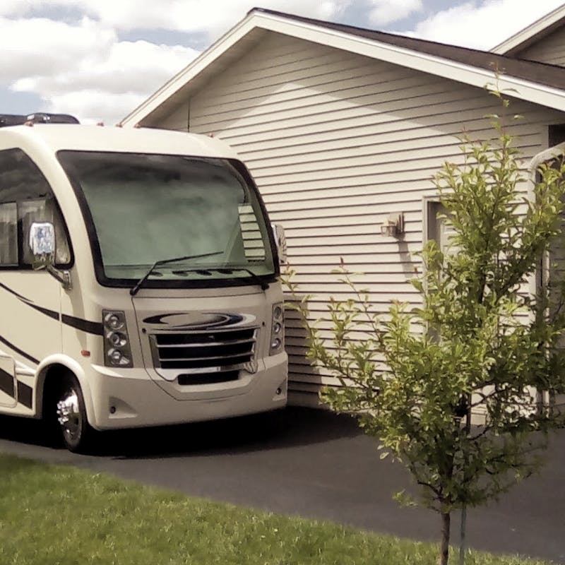 A Thor RV parked in a driveway next to the Bolands' house.