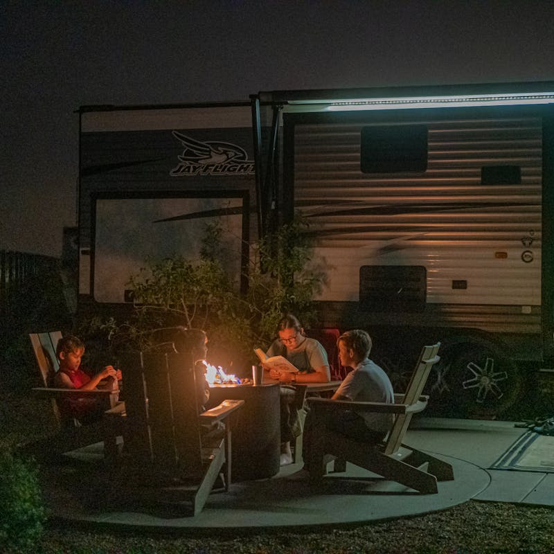 Renee Tilby's family hanging out around a campfire at night in front of their RV