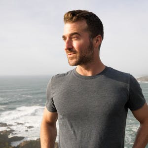 A headshot of Anthony Tori standing in front of the ocean.