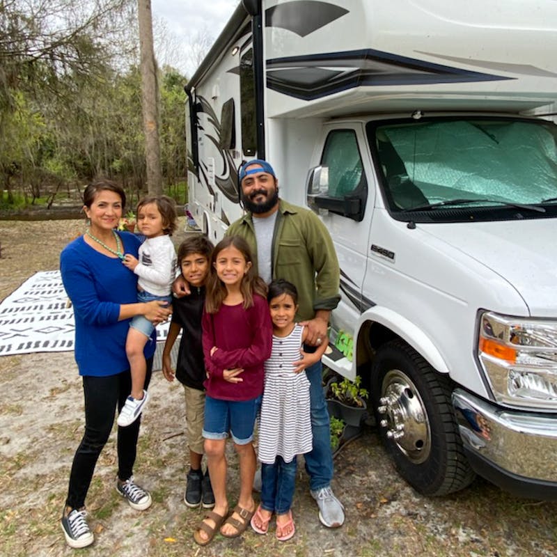 Sandra Peña's family of six poses for a photo in front of their Jayco Class C RV.
