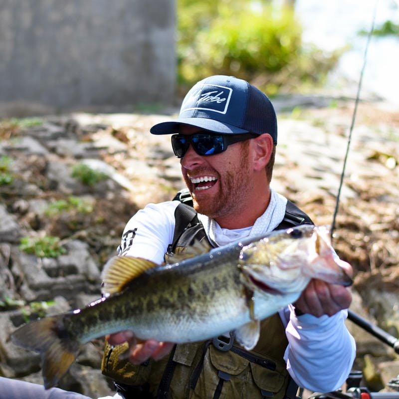Robert holding up a bass he caught.