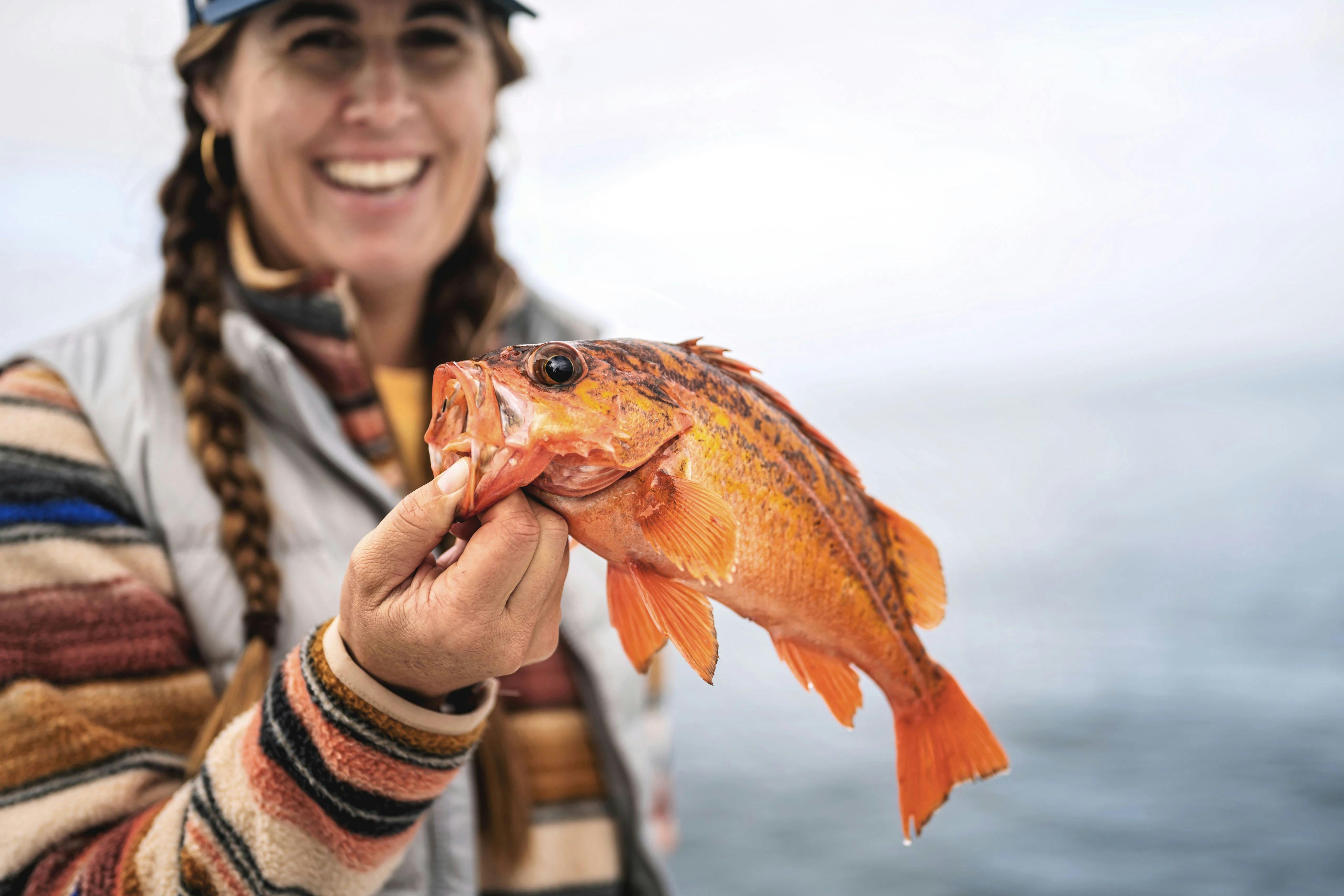 Sarah Glover holding up a rockfish that she just caught.