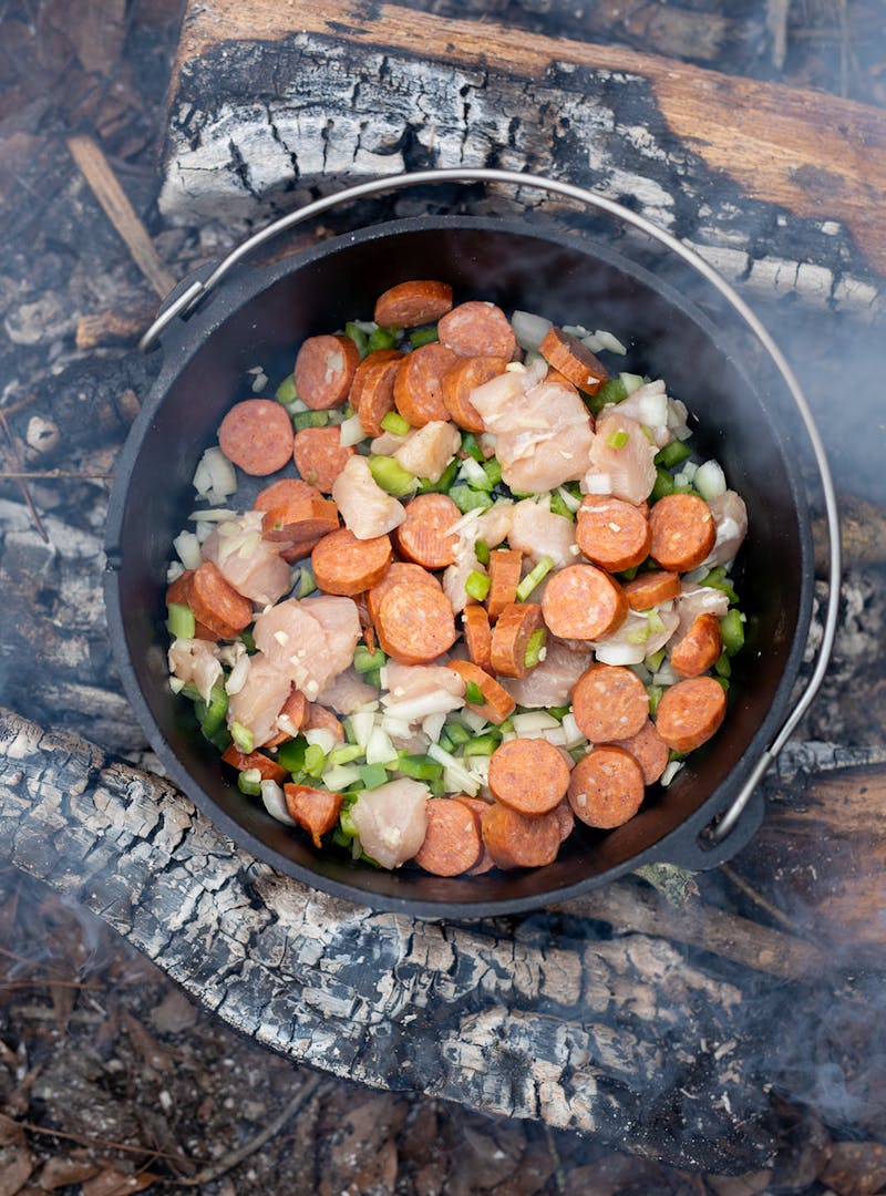 Jambalaya cooking over a campfire.