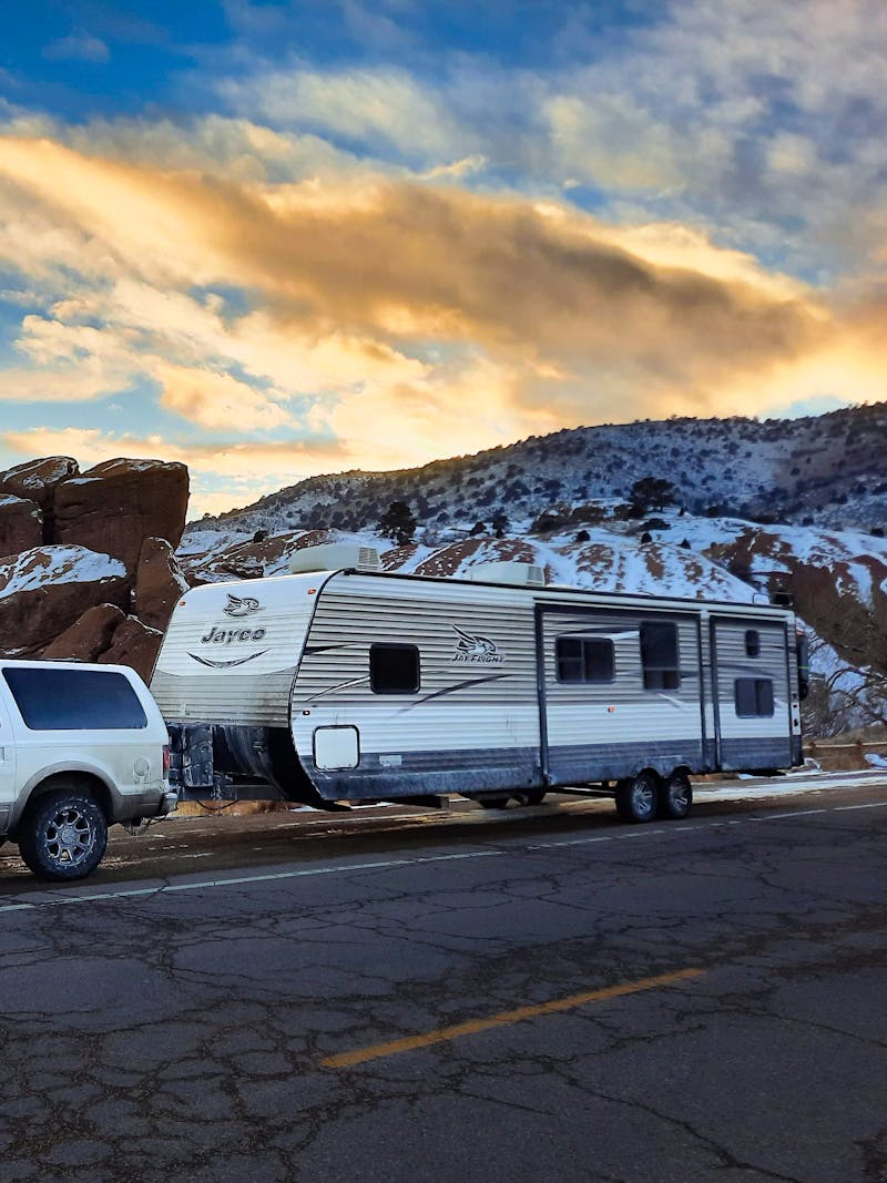 Renee Tilby's Jayco Jay Flight Travel Trailer being towed by her truck through a snow mountainous landscape