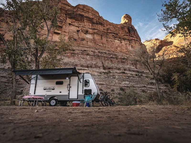 A sportsmen RV parked by large rock structures 
