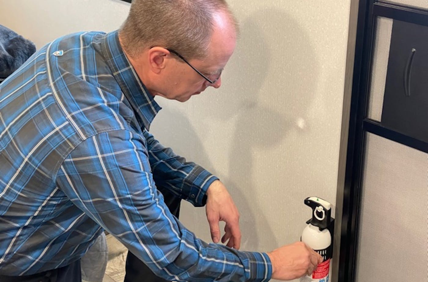 Matt Gleason picking up a fire extinguisher