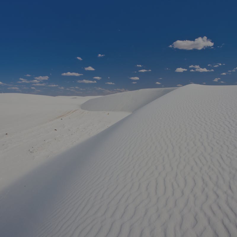 White sand dunes against blue sky at White Sands National Park