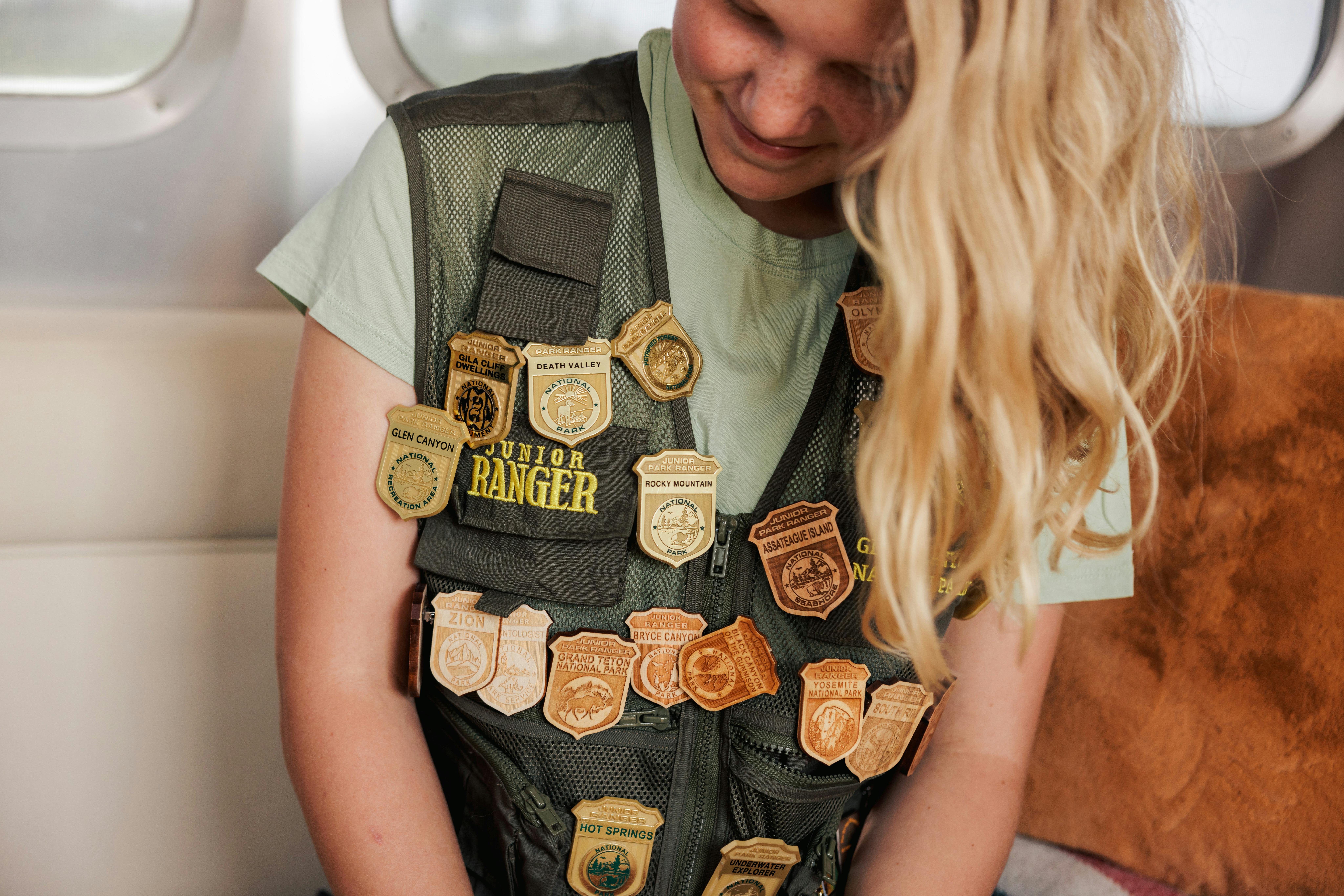 Karen Blue's daughter wearing her Junior Ranger vest with badges from different national parks