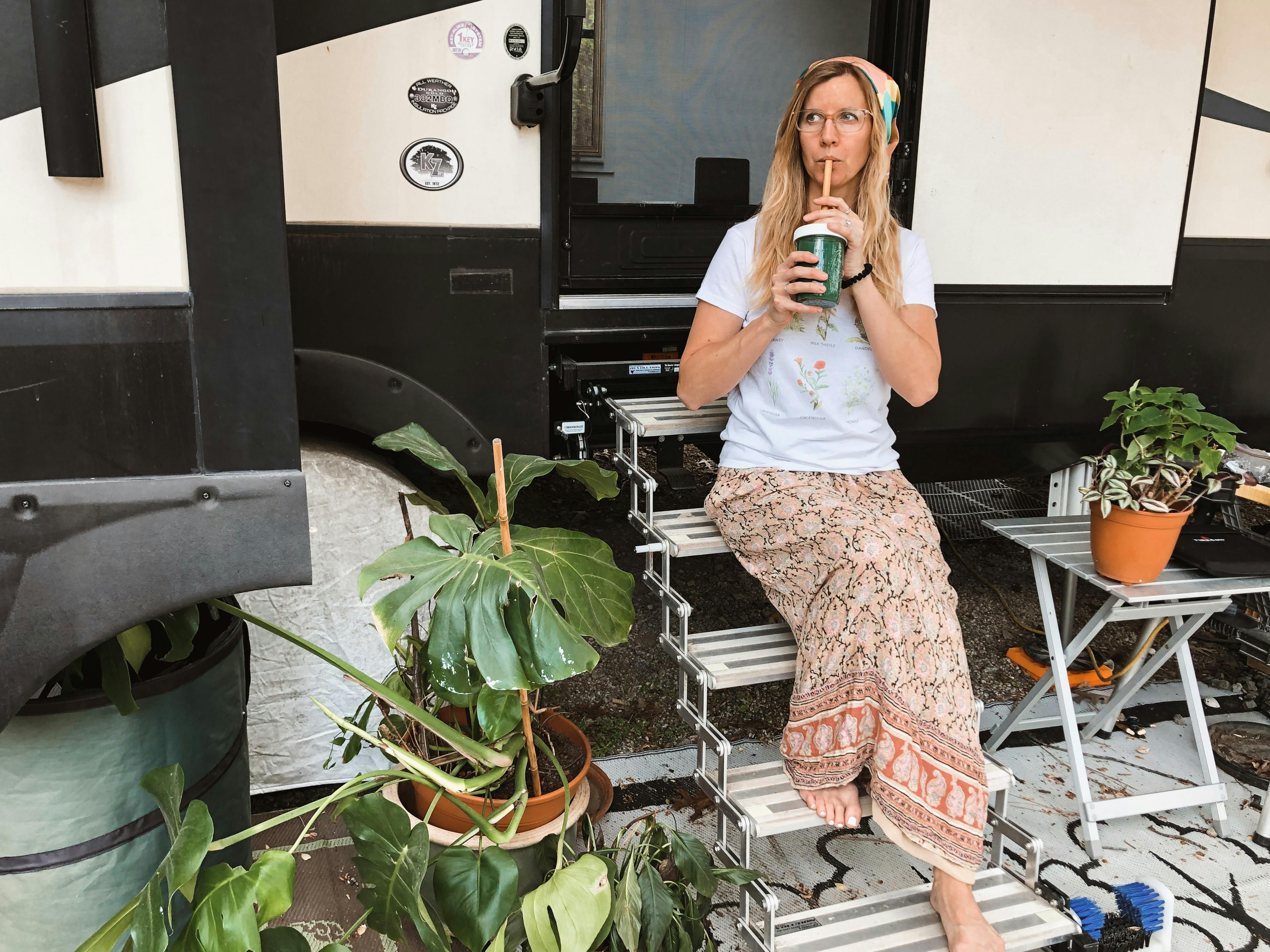 Bibi BARRINGER drinking a green smoothie on her RV steps 