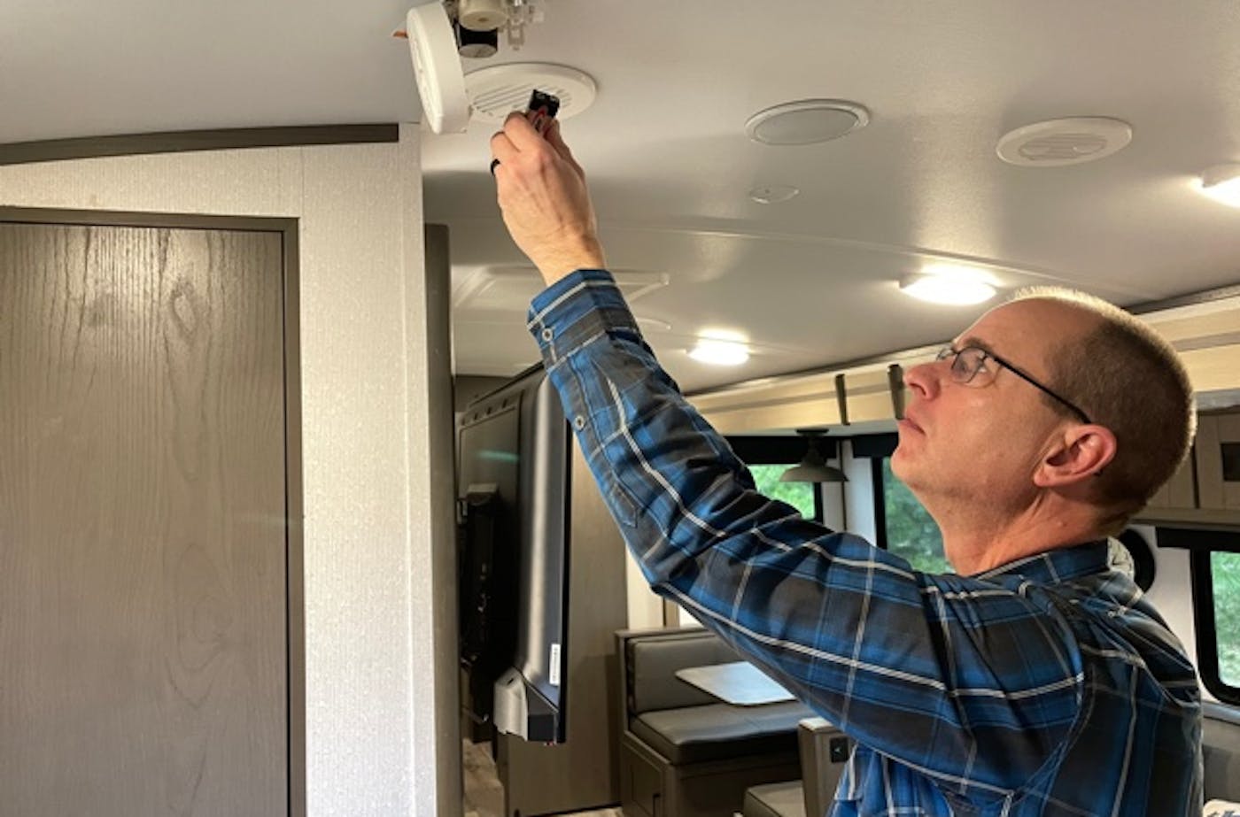 Matt Gleason replacing batteries in a smoke detector