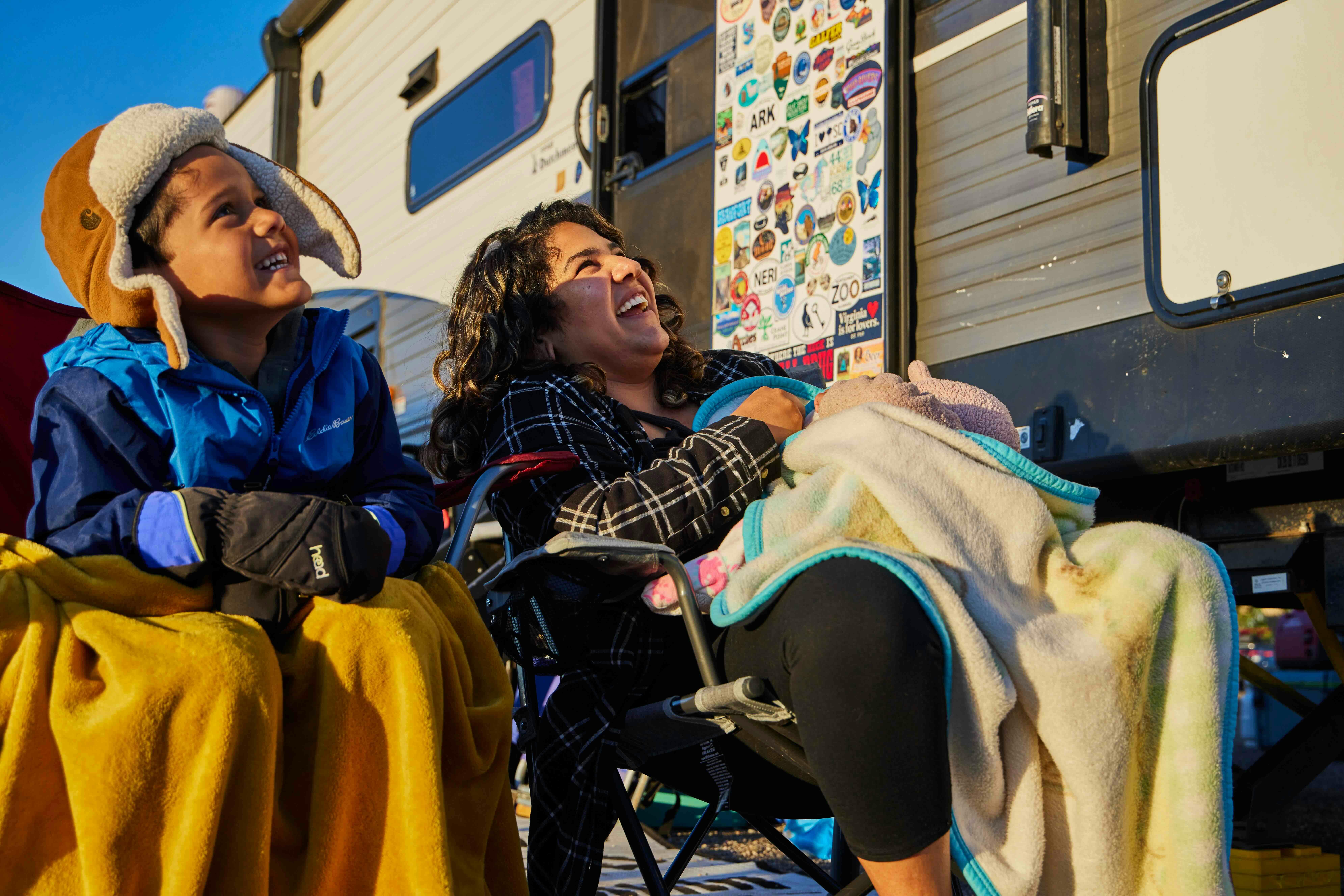 Surna Barton sitting with her kids next to her Coleman Travel Trailer while watching the Albuquerque Balloon Fiesta