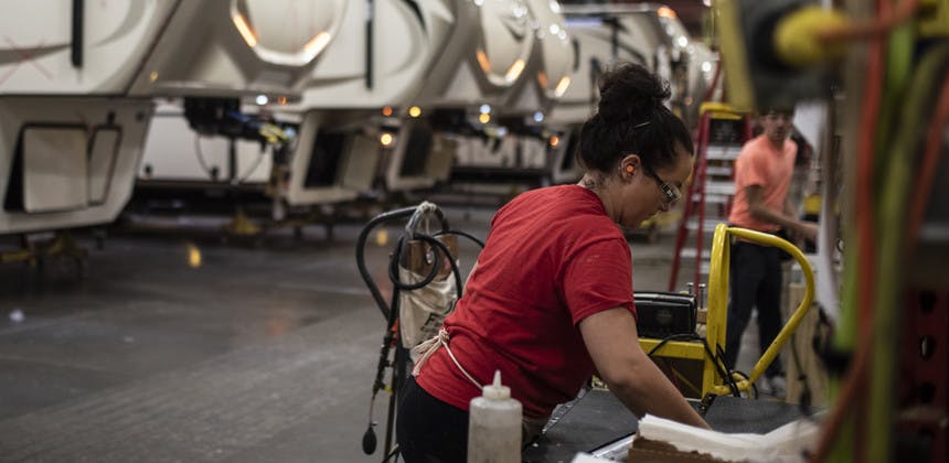 Factory worker in fifth wheel factory, women worker moving tools