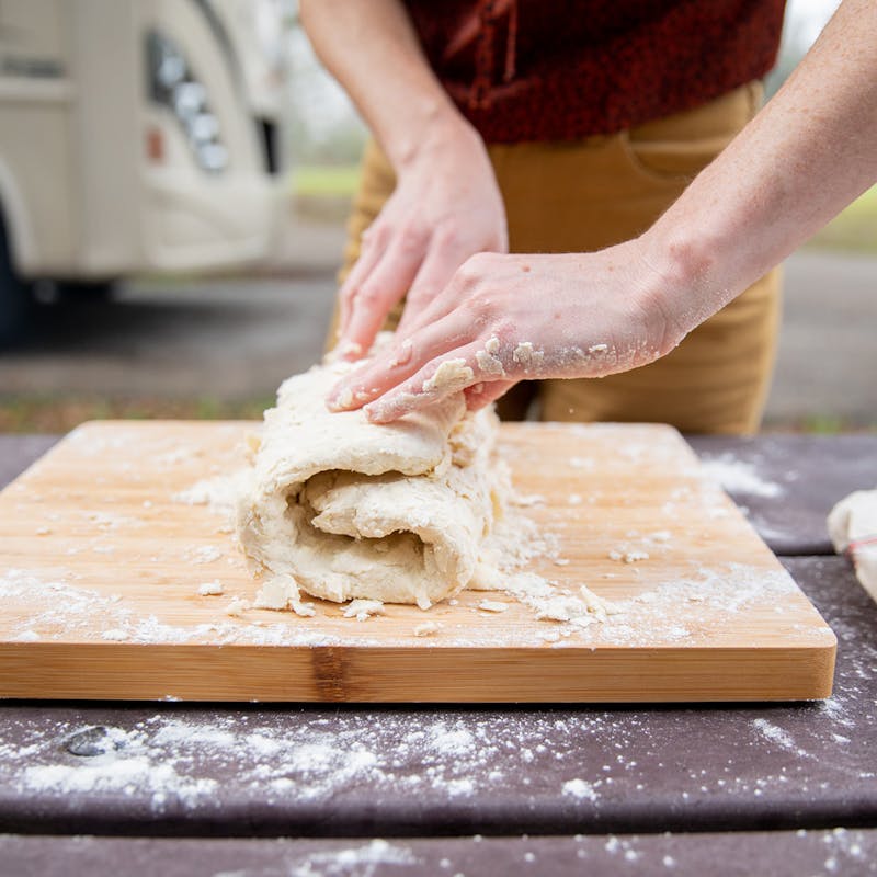 Folding dough on a cutting board.