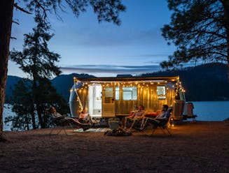 An Airstream trailer in front of a lake