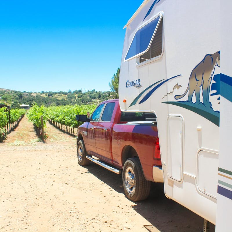 Jesse & Rachael Lyons park their Keystone Cougar RV in front of a vineyard.