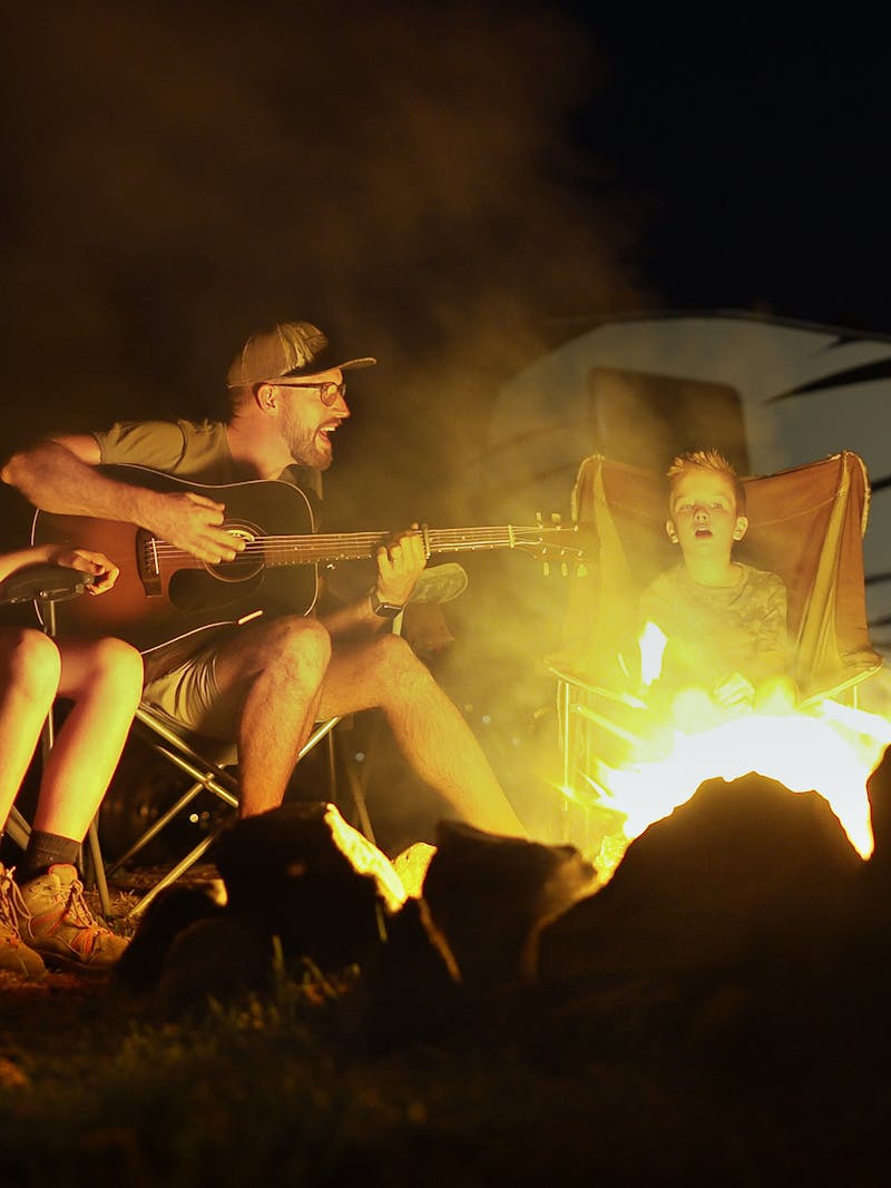 The Cutler family sings around a campfire.