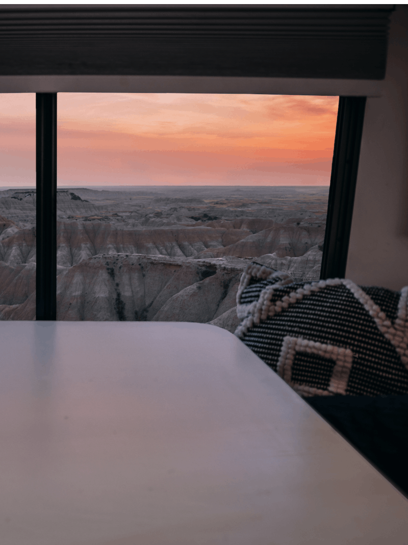 A sunset view out an RV window, facing the landscape of Badlands National Park. 