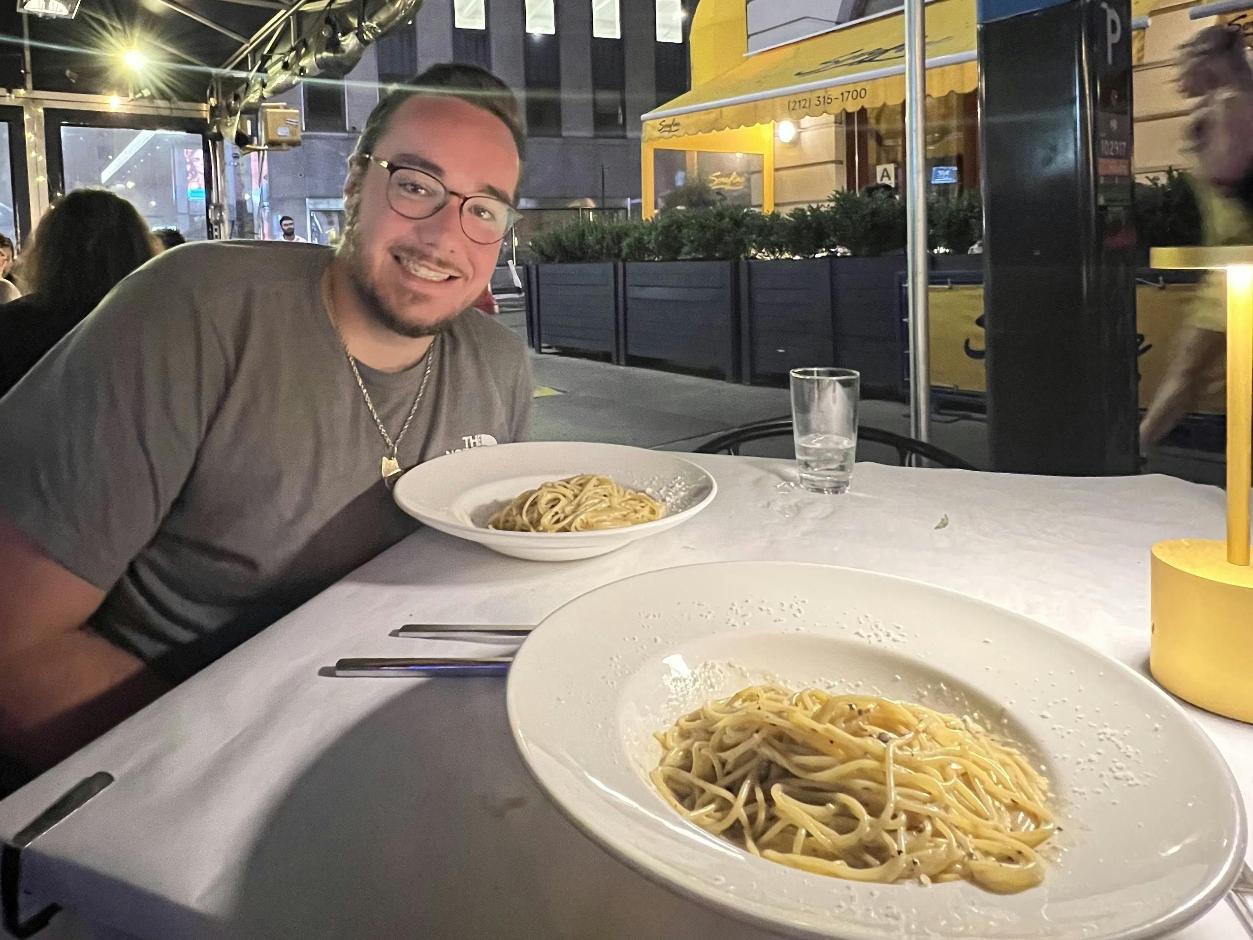 Bailey Damberg smiling at a restaurant with a pasta dinner