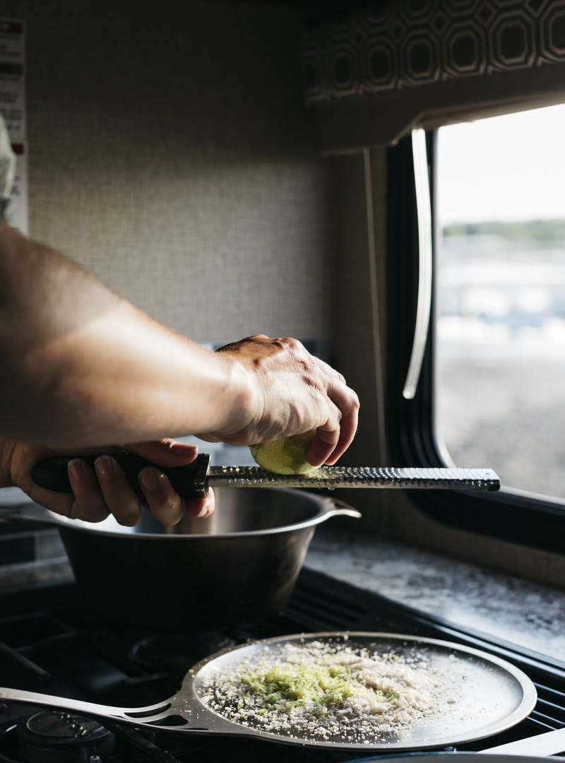 Limes being zested over pot inside the RV kitchen.