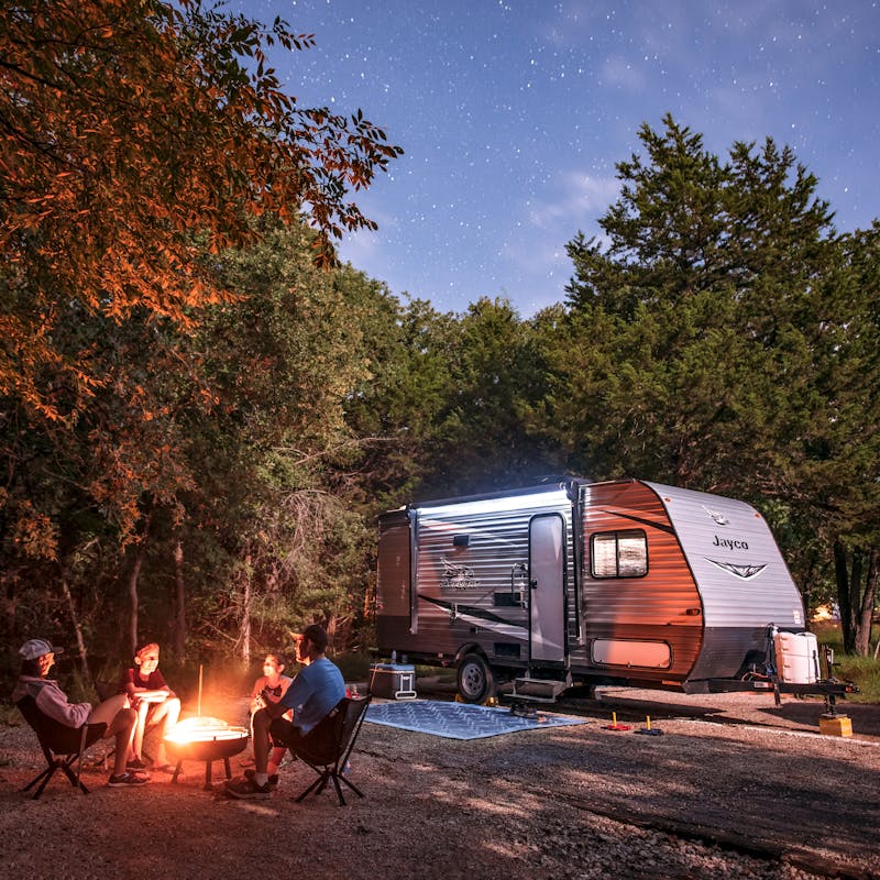 Jason Takacs's family sitting around a campfire next to their Jayco Jay Flight