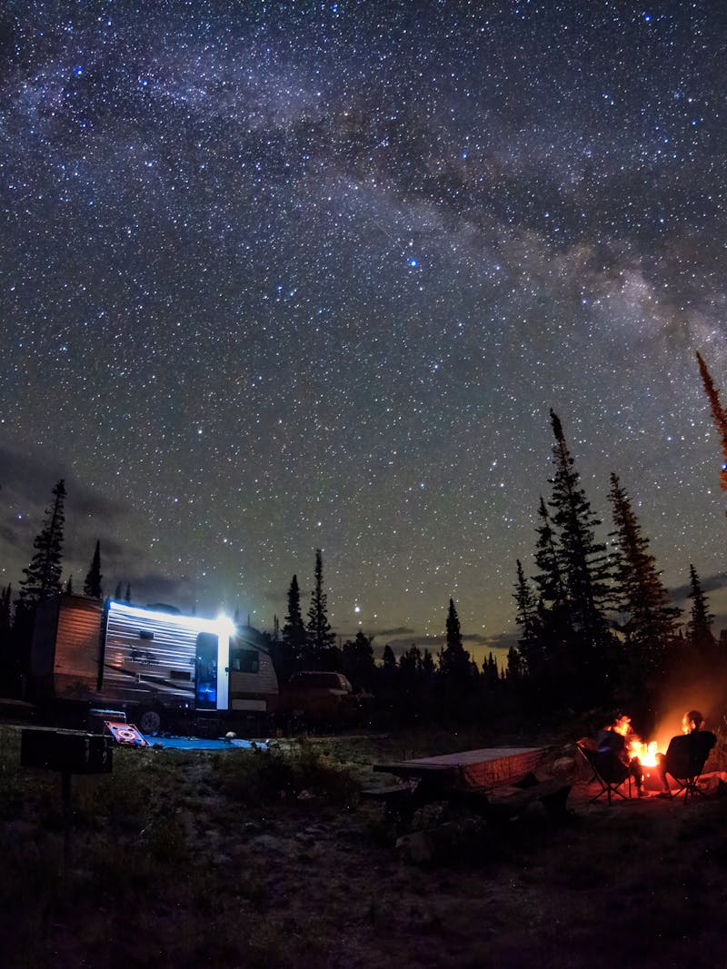 Jason Takacs and his family sitting around a campfire under a starry night sky