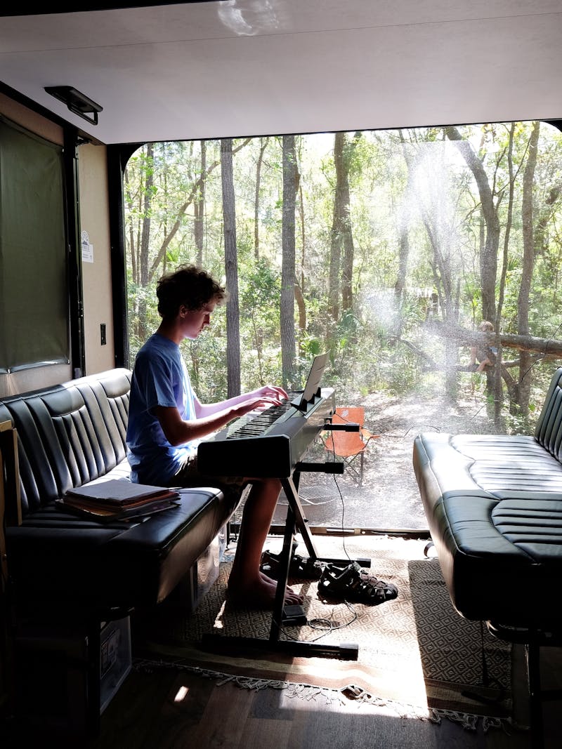 Gretchen Holcomb's son plays a keyboard in the garage of their Jayco Octane Toy Hauler. 