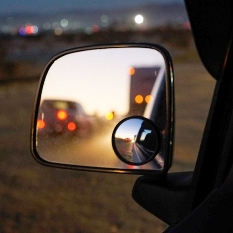 The reflection of RVs through a car's side mirror.