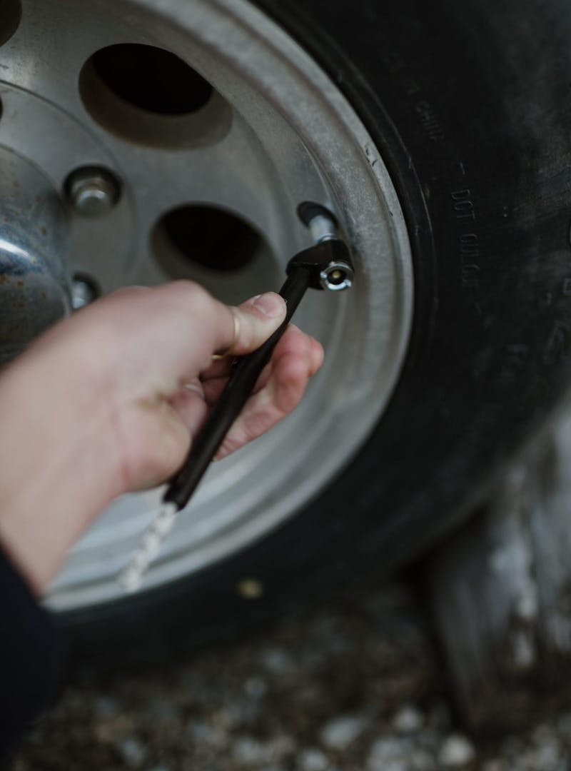 Close up of hand checking tire pressure on RV wheel