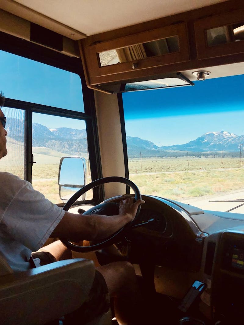 Raoul Martinez driving and RV with snow capped mountains in view.