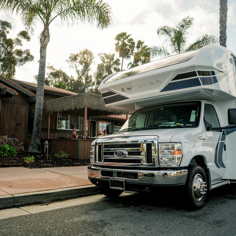 Class C Entegra Coach RV parked in front of small dark wood restaurant