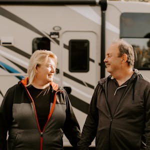 David and Kathy Boland holding hands outside their parked Thor RV.