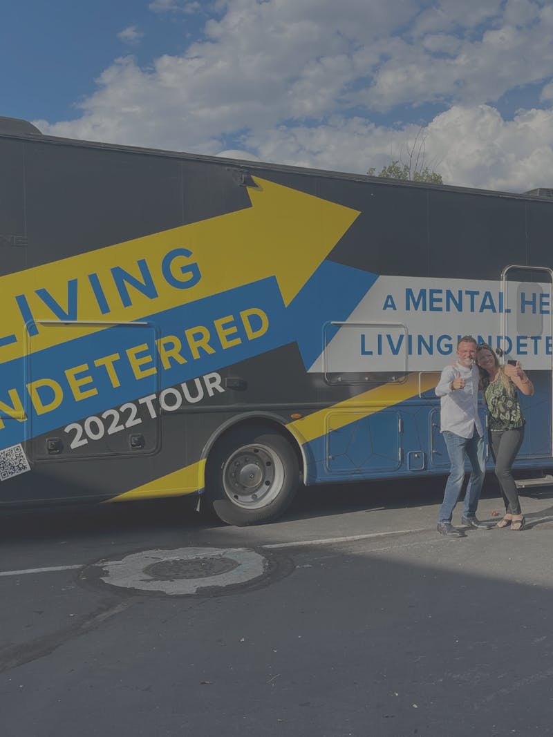 Jeff Johnston posing with a woman giving a thumbs up in front of his RV