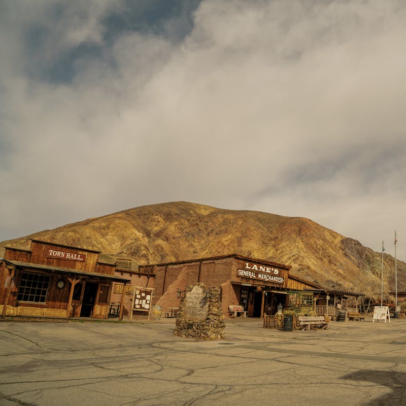 Calico Ghost Town from the parking lot, with old wooden buildings and large brown hills in the background