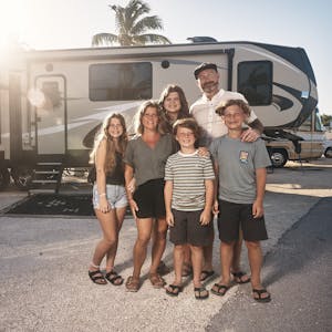 The Lane family pose for a family photo in front of their Keystone Cougar RV