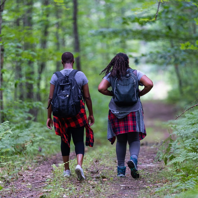 Chanel and Brittany Tate walking through a forest.