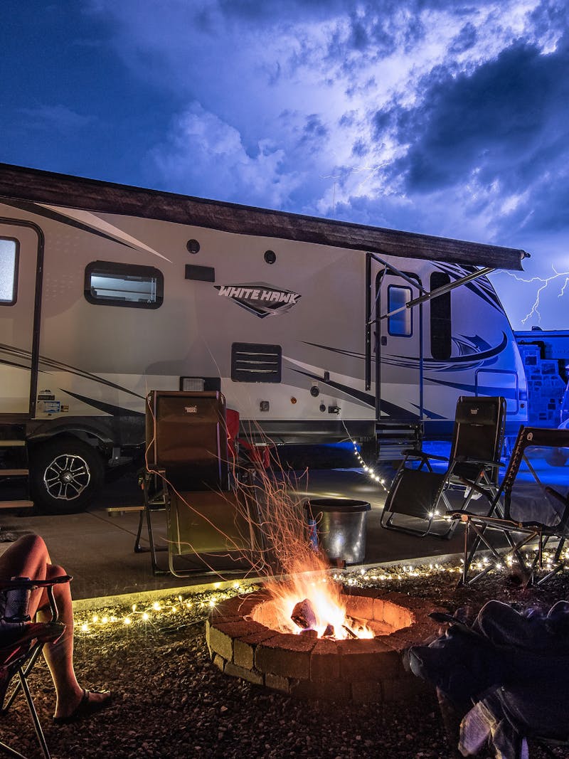 Bill Sferrazza's RV parked at a campsite with family enjoying a campfire at night.