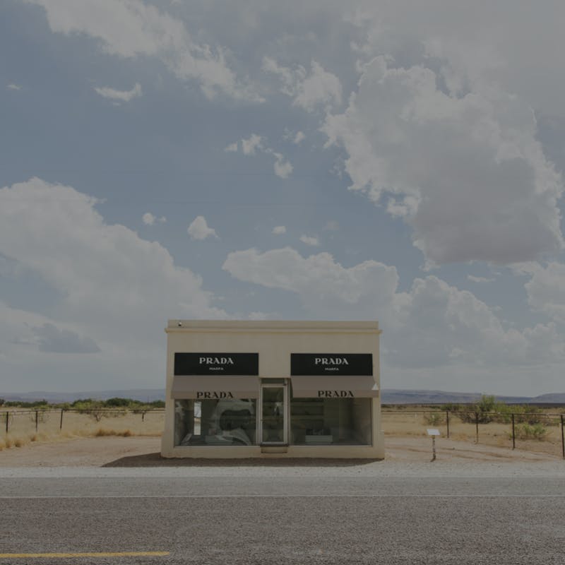 Prada Marfa building on a bright day against blue sky and clouds