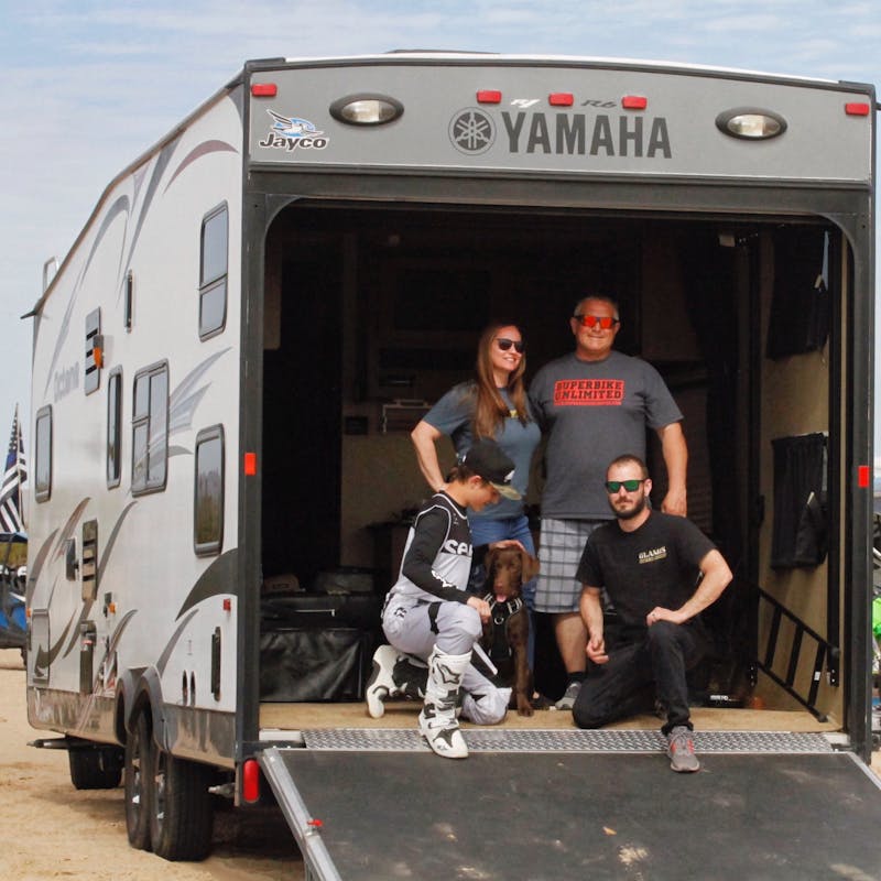 A family of four posed in the back of their Toy Hauler.