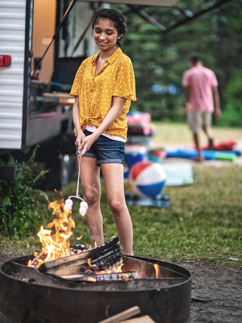 a girl roasting marshmallows over a fire