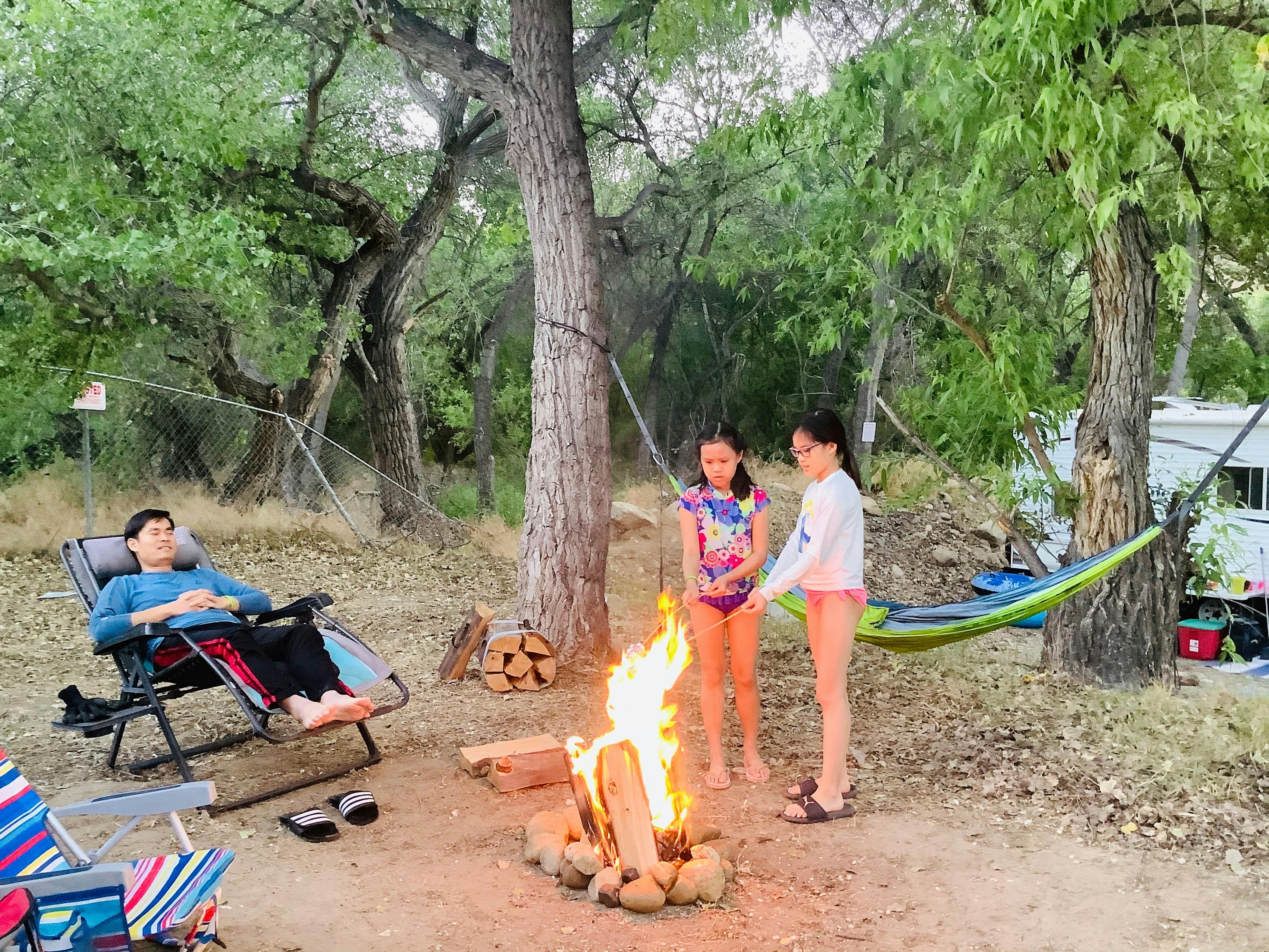 Brenda and Tiger's daughters roasting marshmallows by a campfire